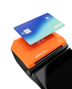 Черная онлайн-касса с оранжевой крышкой принтера чеков, на которой расположен знак бесконтактной оплаты и к ней прикладывается банковская карта